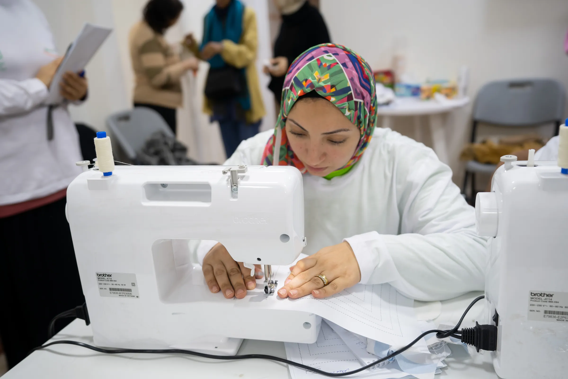 A trainee works with focus at a sewing machine
